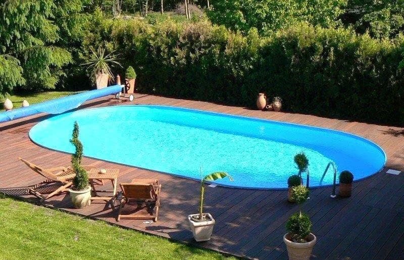 Çitle çevrili bahçede oval Maldiv havuz