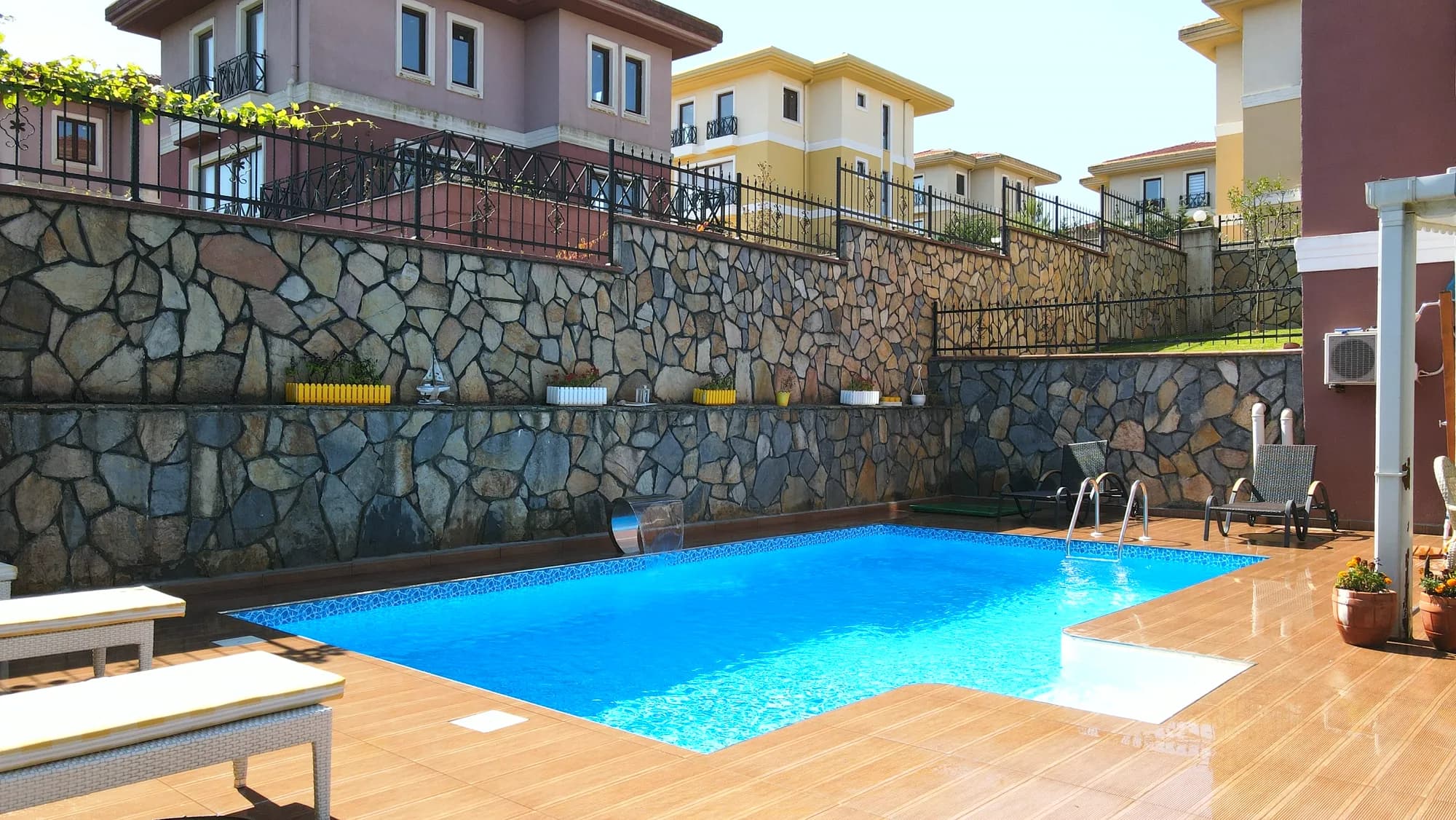Taş duvarlı bahçede panel havuz